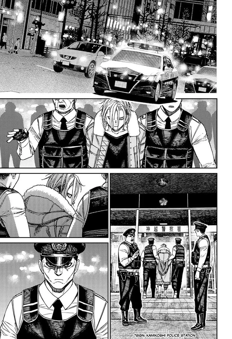 Police cars pass by. The cops bring Zuma to the precinct. Zuma and the cop who arrested him stare at one another.