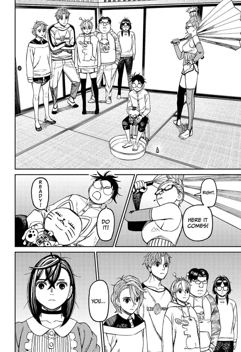 Okarun sits in a chair, his feet on a bowl of water, and Turbo Granny on his lap. Grandma pummels him with a paper fan.